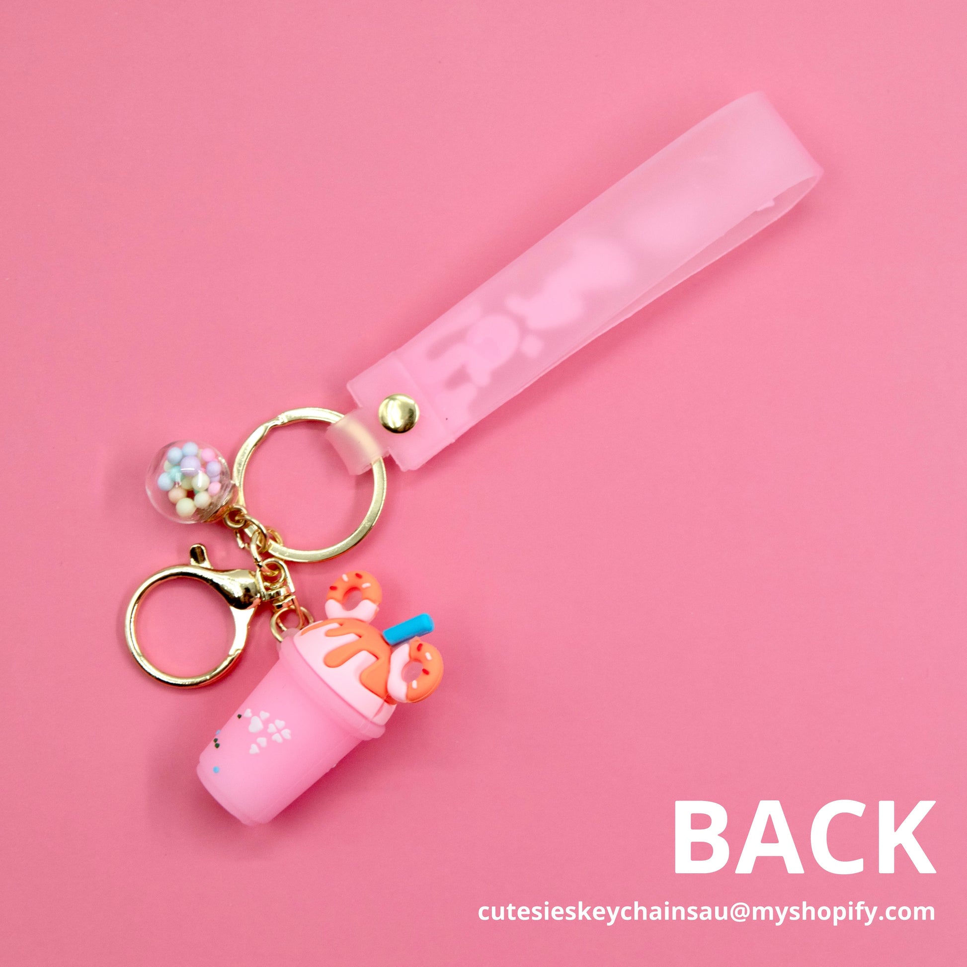 Cute pink boba keychain, with colourful wish ball and a pink wristlet that says “pretty good” on gold keyrings